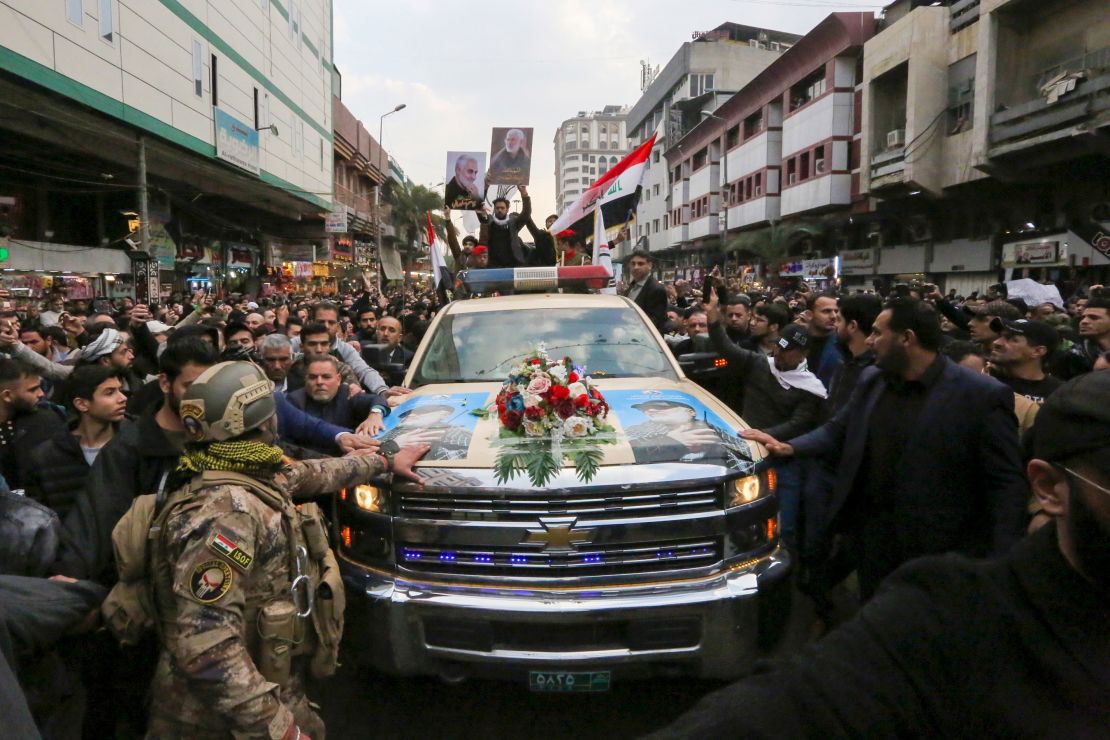 Mourners surround a car carrying  Qasem Soleimani's coffin on Saturday in Baghdad.