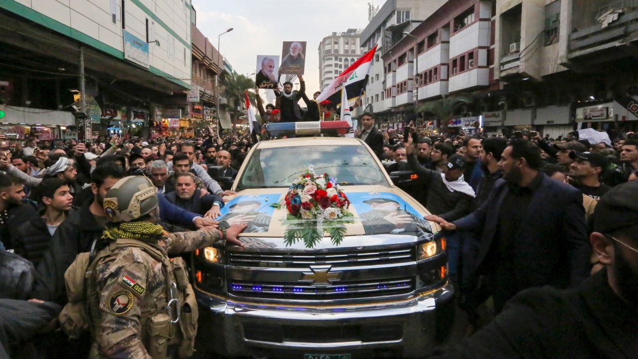 Mourners surround a car carrying  Qasem Soleimani's coffin on Saturday in Baghdad.