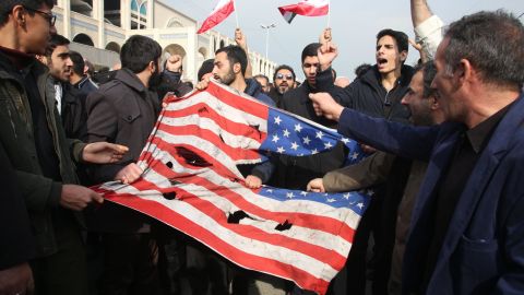  Iranians tear up a US flag during a demonstration in Tehran on January 3, 2020.