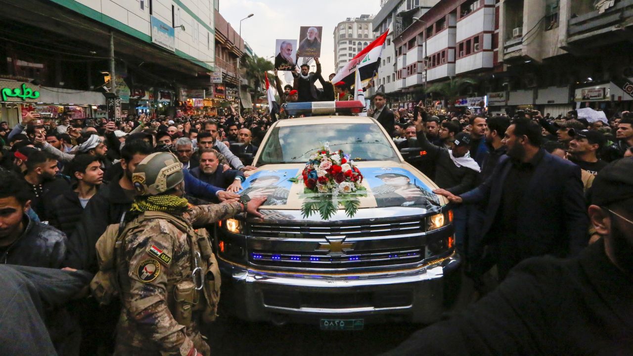 Mourners throng the car carrying the body of Iranian commander Qasem Soleimani during a funeral procession for Soleimani and Iraqi paramilitary leader Abu Mahdi al-Muhandis in Baghdad on January 4.
