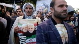 A man holds a picture of Iranian Major-General Qassem Soleimani, head of the elite Quds Force, and Iraqi militia commander Abu Mahdi al-Muhandis, who were killed in an air strike at Baghdad airport, during their funeral procession in Ahvaz, Iran January 5, 2020. Hossein Mersadi/Fars news agency/WANA (West Asia News Agency) via REUTERS ATTENTION EDITORS - THIS IMAGE HAS BEEN SUPPLIED BY A THIRD PARTY