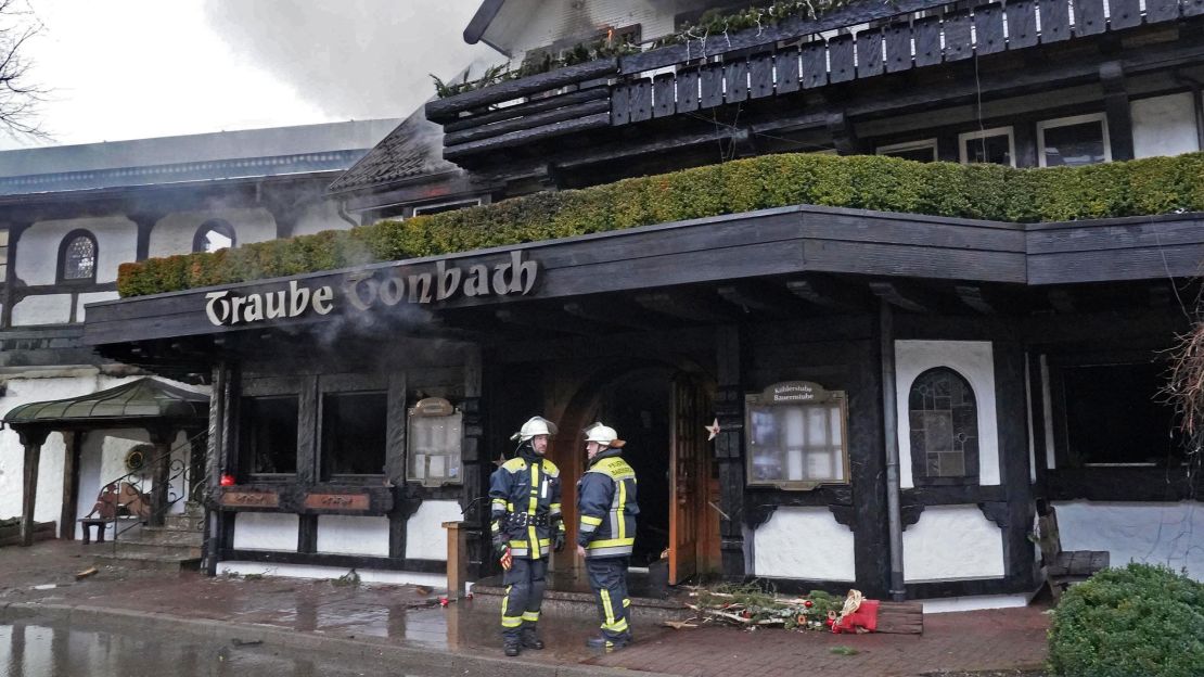 Firefighters stand in front of the Traube Tonbach Hotel after the blaze.