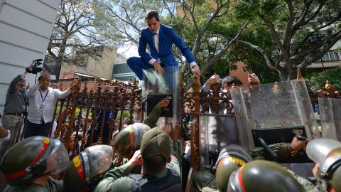 National Assembly President Juan Guaido, Venezuela's opposition leader, tries to climb the fence to enter the compound of the Assembly, after he and other opposition lawmakers were blocked by police from entering a session on Jan. 5, 2020.