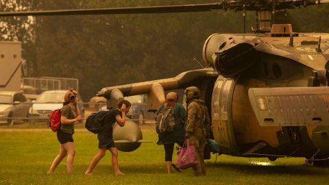 An Australian army soldier helps people evacuate onto a Black Hawk helicopter in Omeo, Victoria on January 5, 2020.