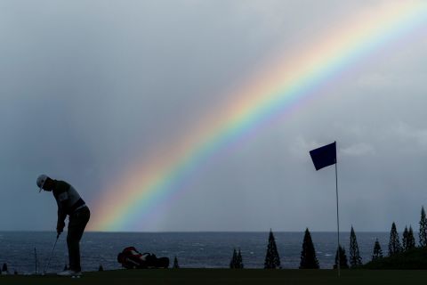 A rainbow is seen behind Gary Woodland as he practices his putting at the Tournament of Champions on Friday, January 3. The event is held every year on the Hawaiian island of Maui. 