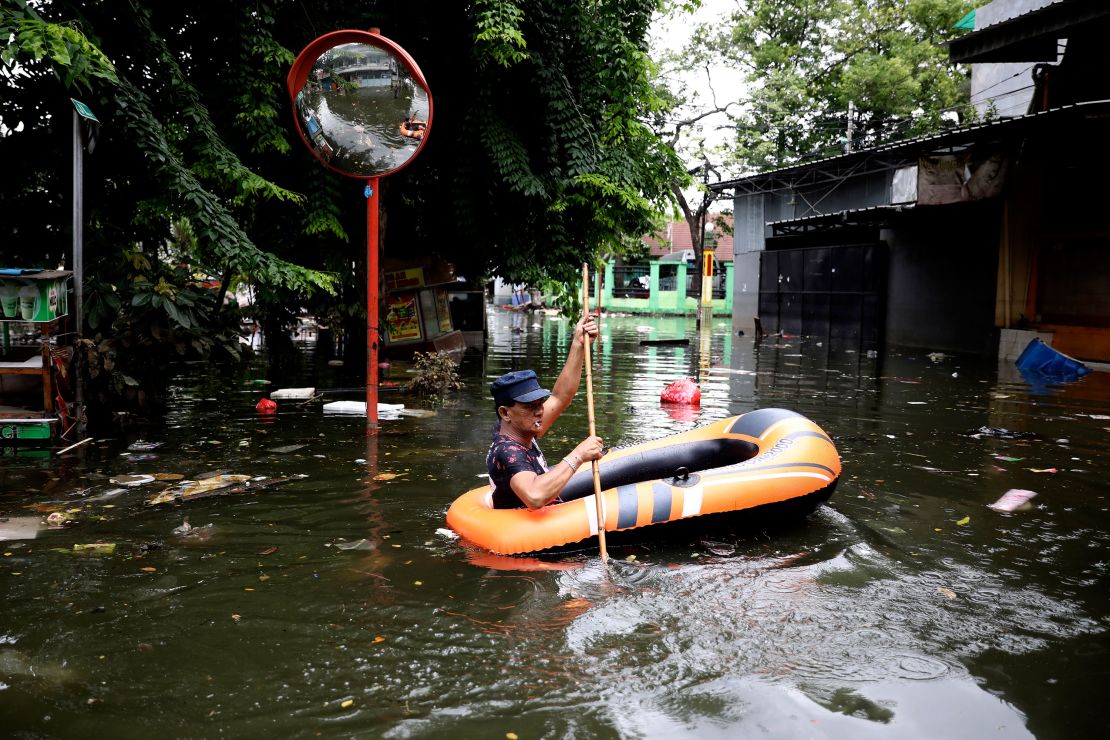 A man navigates an inflatable boat at a flooded neighborhood in Jakarta on Saturday.