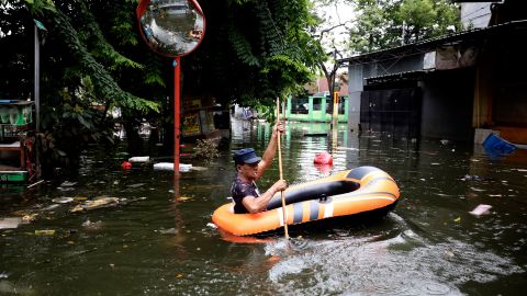 A man navigates an inflatable boat at a flooded neighborhood in Jakarta on Saturday.