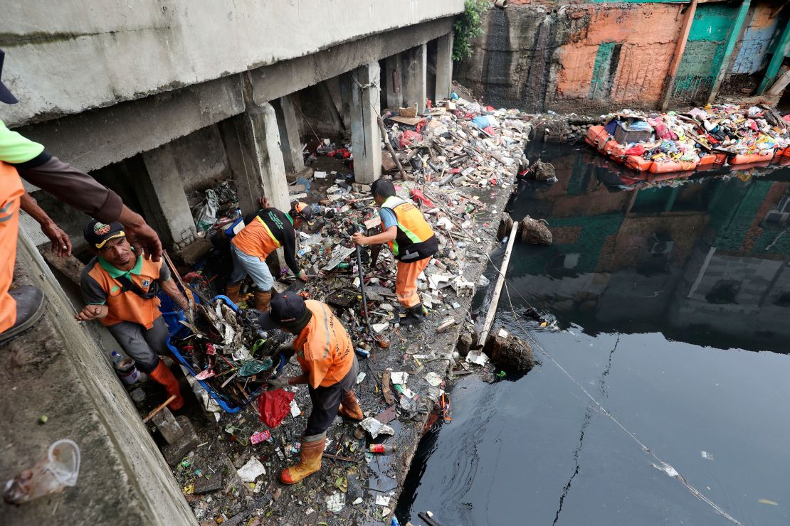 Workers collect trash during a clean up after flooding in Jakarta on Sunday.