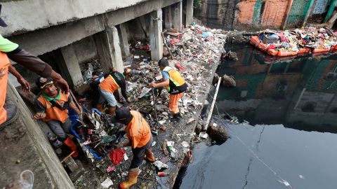 Workers collect trash during a clean up after flooding in Jakarta on Sunday.