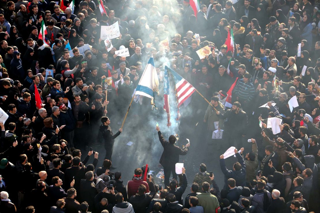 Iranians set a US and an Israeli flag on fire during Soleimani's funeral procession.