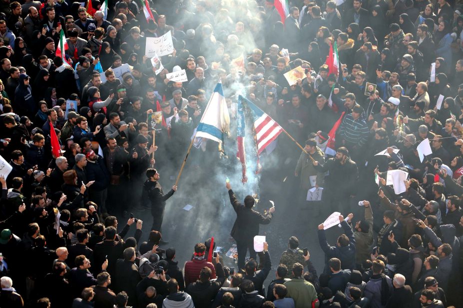 Iranians set a US and an Israeli flag on fire during the funeral procession.