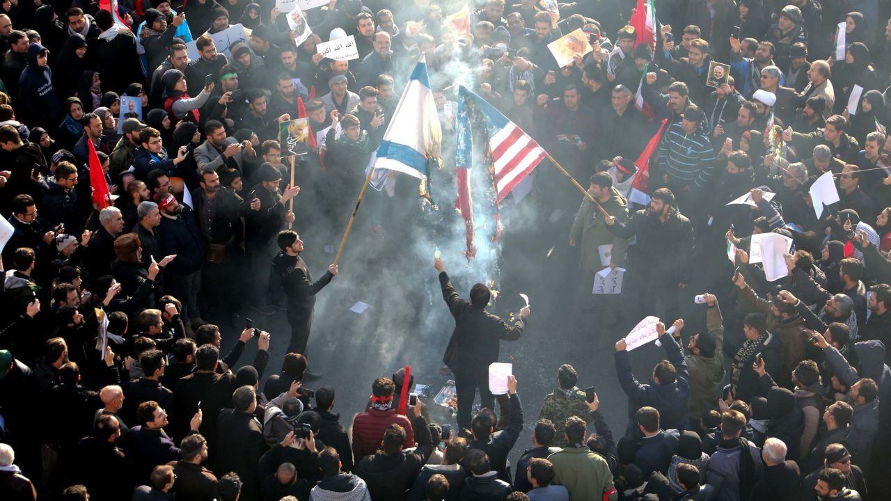 Iranians set a US and an Israeli flag on fire during Soleimani's funeral procession.