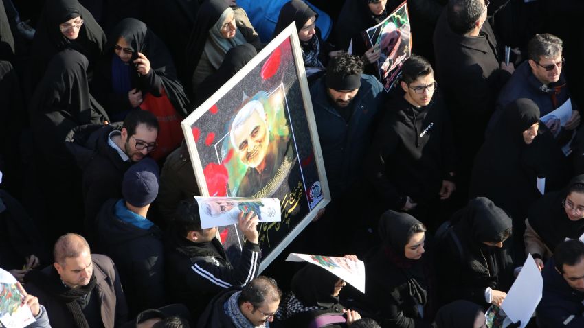 Mourners carry a picture of mourn slain Iranian military commander Qasem Soleimani, as they walk in a funeral procession organised to pay hommage to him as well as Iraqi paramilitary chief Abu Mahdi al-Muhandis and other victims of a US attack in the capital Tehran on January 6, 2020. - Mourners packed the streets of Tehran for ceremonies to pay homage to Soleimani, who spearheaded Iran's Middle East operations as commander of the Revolutionary Guards' Quds Force and was killed in a US drone strike on January 3 near Baghdad airport. (Photo by Atta KENARE / AFP) (Photo by ATTA KENARE/AFP via Getty Images)