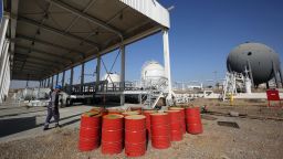 An Iraqi oil employee walks past oil barrels at the Bai Hassan oil field, west of the multi-ethnic northern Iraqi city of Kirkuk, on October 19, 2017. Kurdish peshmerga forces withdrew without a fight after federal government troops and militia entered Kirkuk, seizing the provincial governor's office and key military bases in response to a Kurdish vote for independence in September 2017. (Photo credit should read AHMAD AL-RUBAYE/AFP via Getty Images)