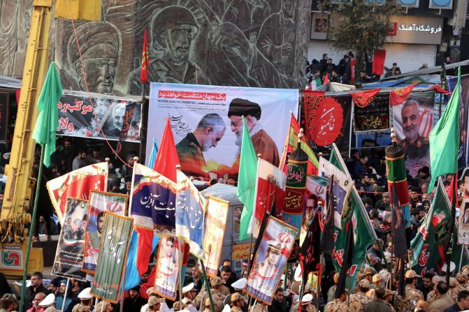 People carry placards and flags during the funeral procession.