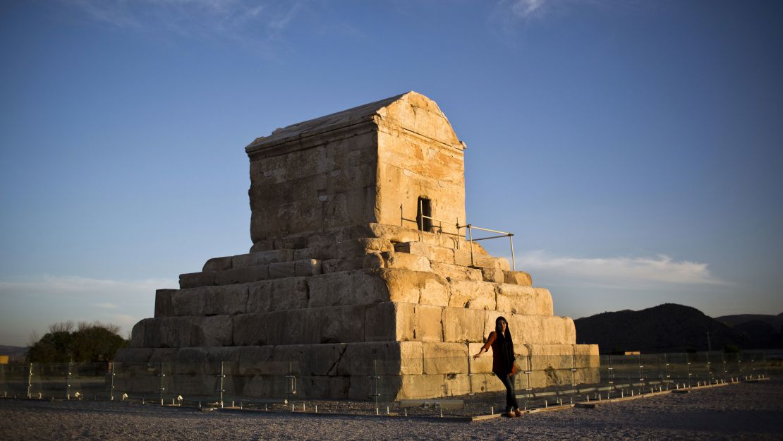 A woman poses in front of the tomb of Cyrus the Great, in the town of Pasargadae.