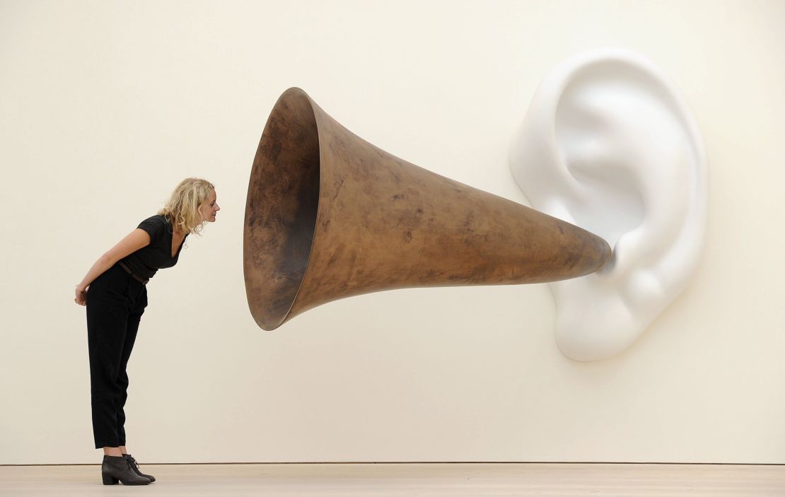 A gallery employee poses next to Baldessari's sculpture "Beethoven's Trumpet (With Ear)" at the Saatchi Gallery in London.