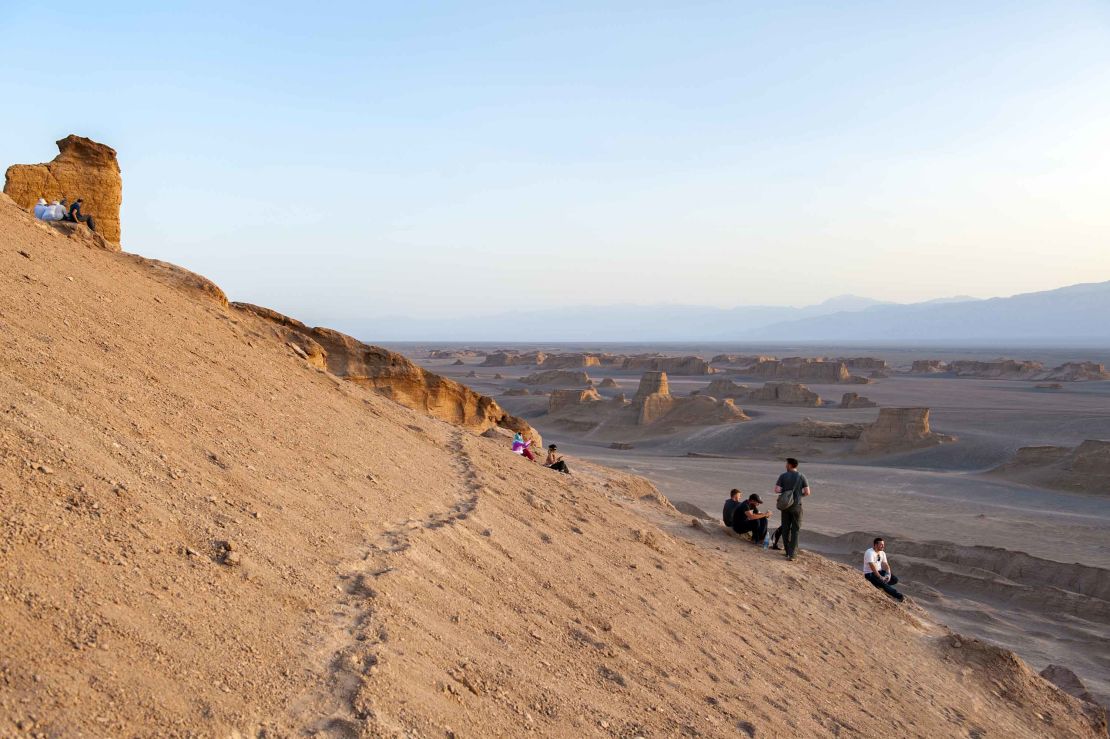 Tourists watch the sun go down over the Lut desert in Shahad.