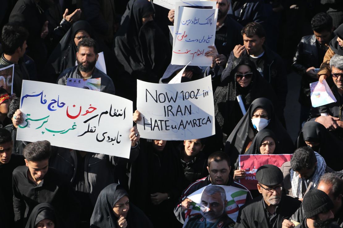 Iranian mourners hold placards at the funeral of Qasem Soleimani in Kerman, Iran, on Tuesday. 