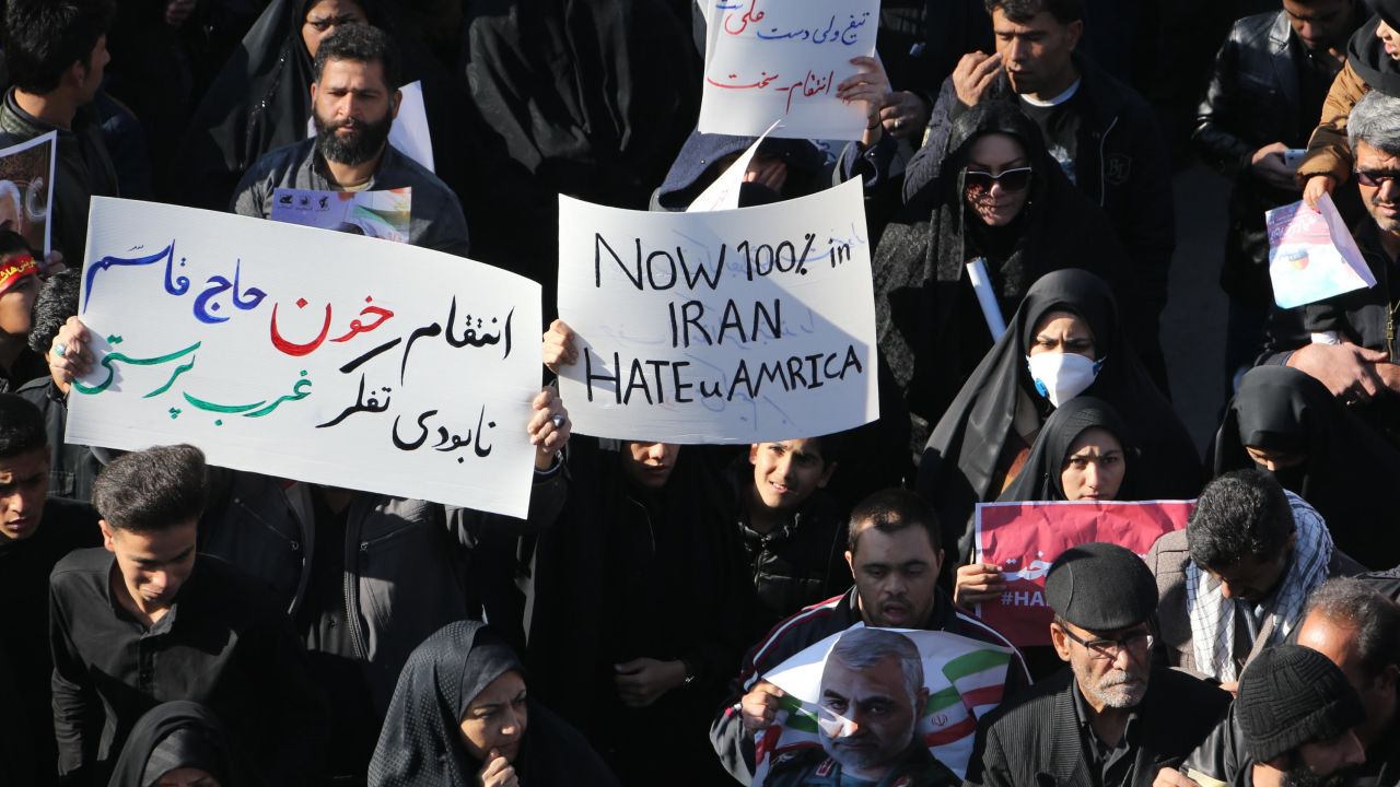 Iranian mourners hold placards at the funeral of Qasem Soleimani in Kerman, Iran, on Tuesday.
