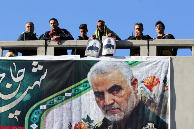 Mourners view the funeral procession from a bridge in Kerman.