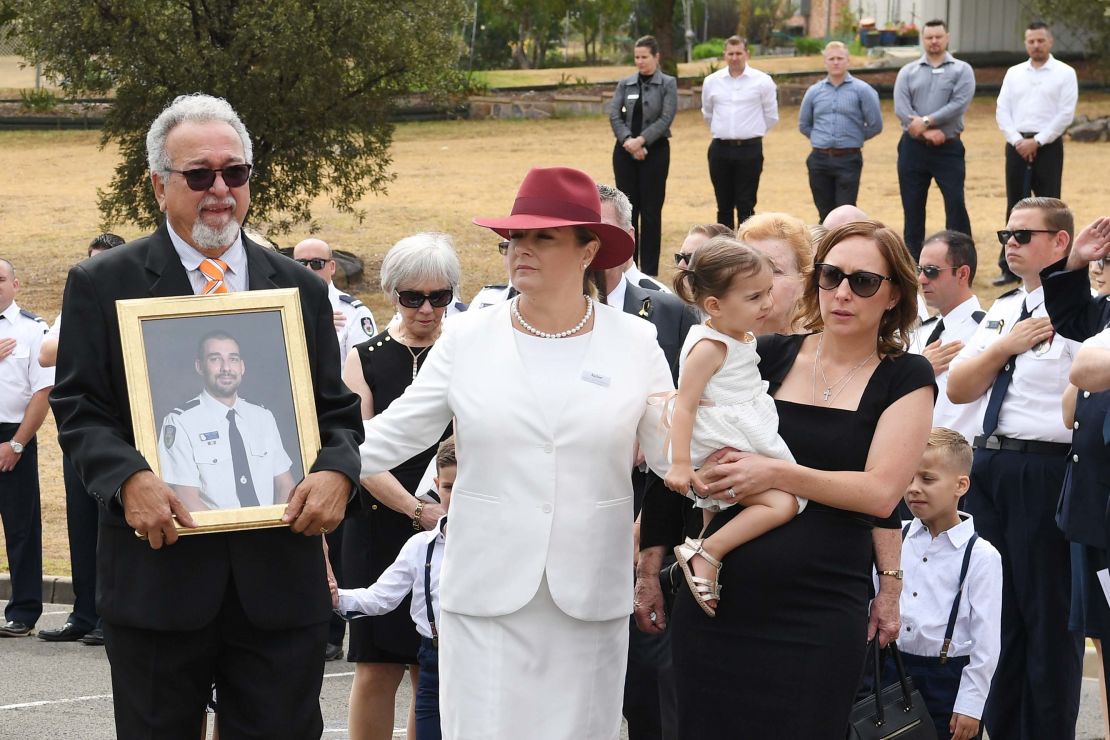 O'Dwyer's father, Errol, wife Melissa (in black) and young daughter Charlotte carried a portrait of the fallen firefighter at his funeral. 