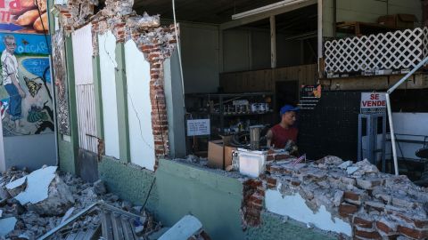 Shop owners and employees help clear the rubble of a collapsed hardware store in Guanica.