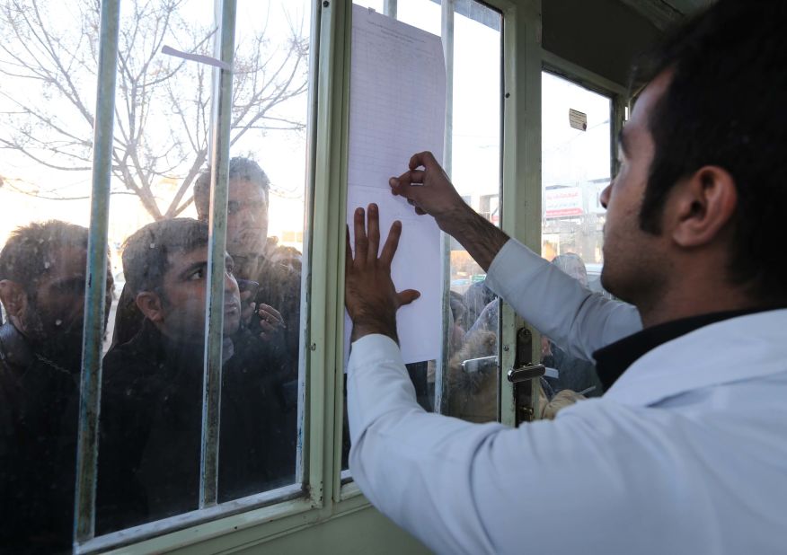 Relatives check a list of stampede victims at a hospital in Kerman.