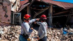 TOPSHOT - Two firemen survey a collapsed building after an earthquake hit the island in Guanica, Puerto Rico on January 7, 2020. - A strong earthquake struck south of Puerto Rico early January 7, 2020 followed by major aftershocks, the US Geological Survey said, the latest in a series of tremors that have shaken the island since December 28. The shallow 6.4 magnitude quake struck five miles (eight kilometers) south of the community of Indios, the USGS said, revising down its initial reading of 6.6. (Photo by Ricardo ARDUENGO / AFP) (Photo by RICARDO ARDUENGO/AFP via Getty Images)