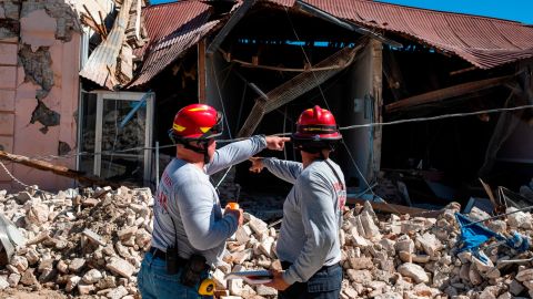 Firefighters survey a collapsed building after an earthquake hit Guanica on January 7.