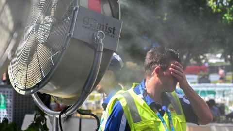 A man cools down in front of a mist fan for relief from the hot weather in Melbourne, Australia. 