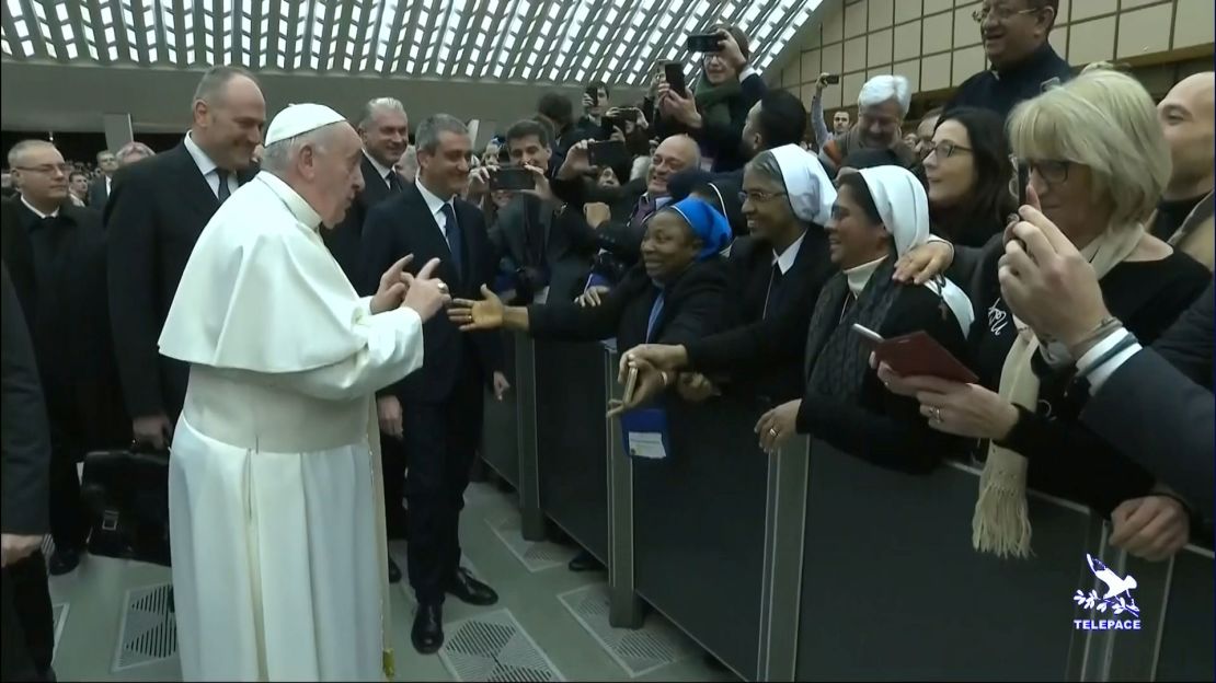 Pope Francis gestures as he jokes to a nun "You bite! I will give you a kiss but you stay calm. Don't bite!"