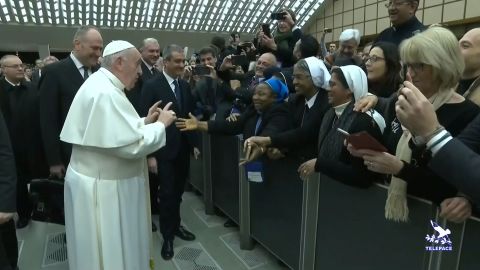 Pope Francis gestures as he jokes to a nun "You bite! I will give you a kiss but you stay calm. Don't bite!"