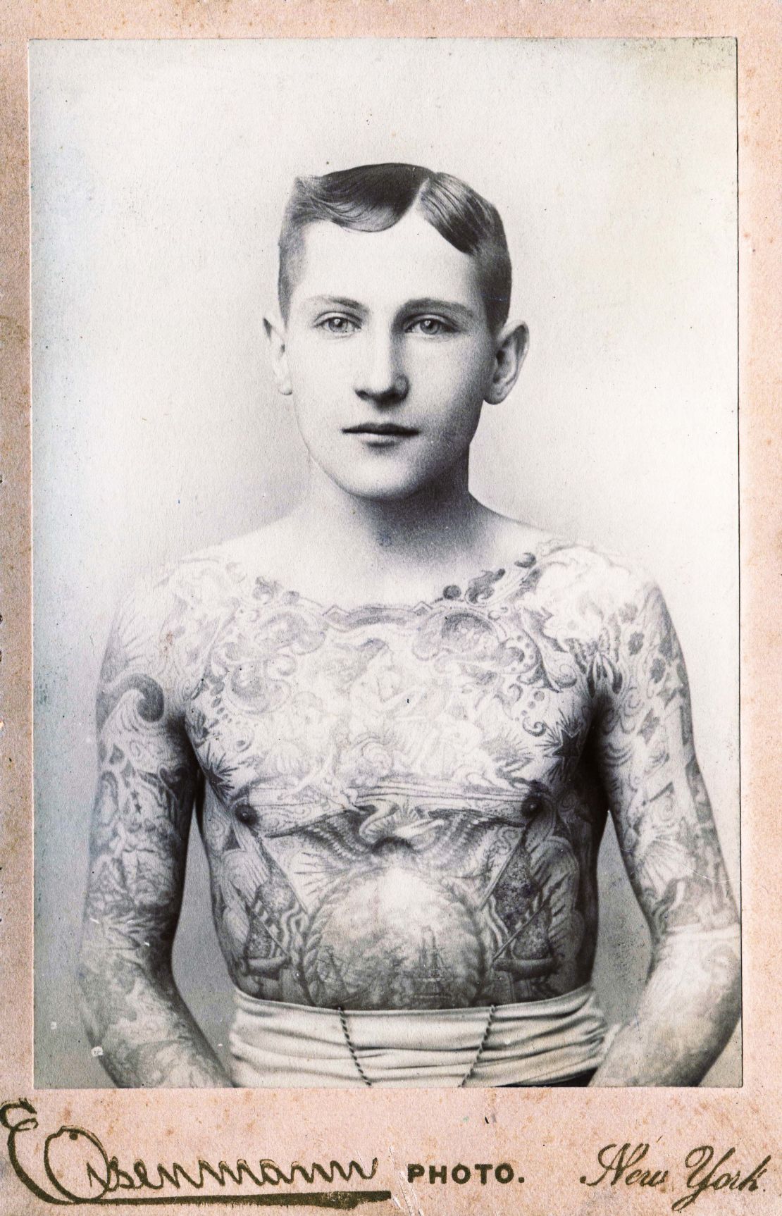 Cabinet photograph, by Eisenmann, of a young man with his entire chest and arms tattooed, New York, circa 1890. 