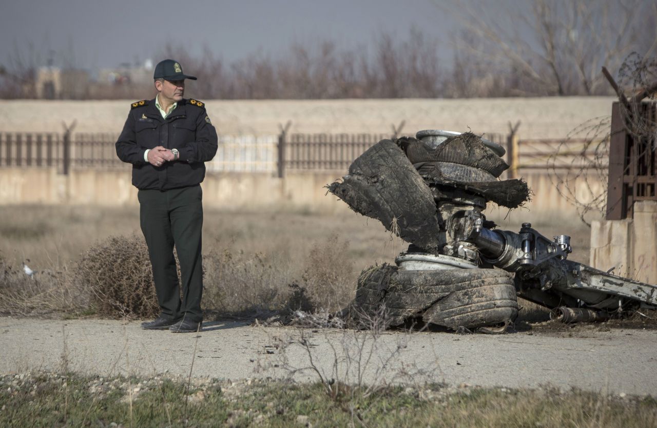 An official stands near a piece of plane wreckage.