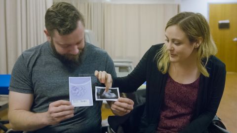 Drew and Jennifer Gobrecht holding ultrasound images of their son Benjamin Thomas Gobrecht after finding out that they are pregnant.