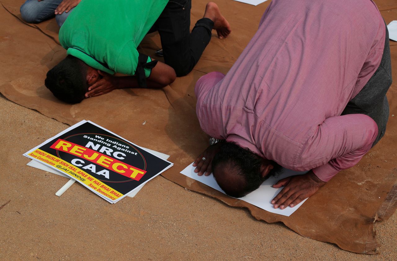 Placards lie next to Indian Muslims offering prayers during a protest on Saturday, January 4.