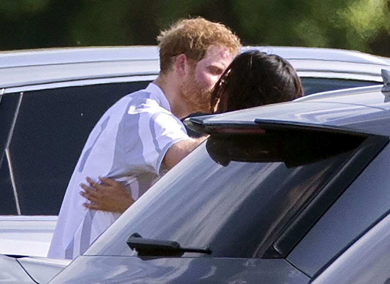 Harry and Meghan embrace at a polo match in May 2017.