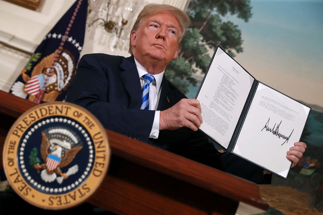 US President Donald Trump holds up a memorandum reinstating sanctions on Iran after he announced the US would withdraw from the Iran nuclear deal, at the White House on May 8, 2018.