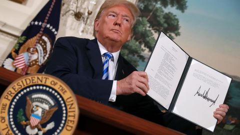 US President Donald Trump holds up a memorandum reinstating sanctions on Iran after he announced the US would withdraw from the Iran nuclear deal, at the White House on May 8, 2018.