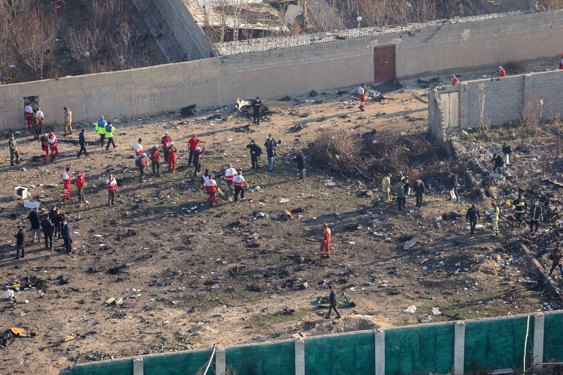 Rescue teams gather where a plane crashed in Tehran early January 8, killing all 176 people aboard.