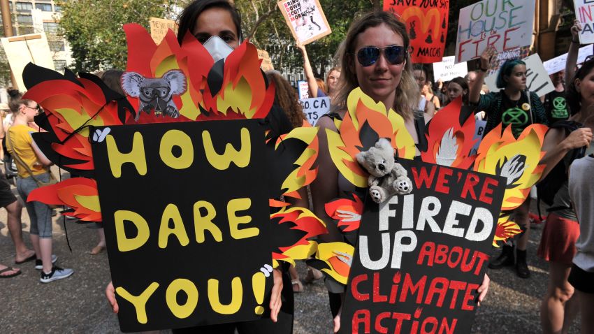 Participants hold placards as they take part in a demonstration demanding the government take immediate action against climate change in Sydney on January 10, 2020, in the wake of deadly bushfires that have killed at least 26 people and destroyed more than 2,000 homes in southeastern Australia. - Tens of thousands of Australians rallied across cities on January 10 as deadly climate-fuelled bushfires swept across the vast continent, calling for the conservative government to act on global warming and cut back on its dependence on fossil fuels. (Photo by Mohammad Farooq / AFP) (Photo by MOHAMMAD FAROOQ/AFP via Getty Images)
