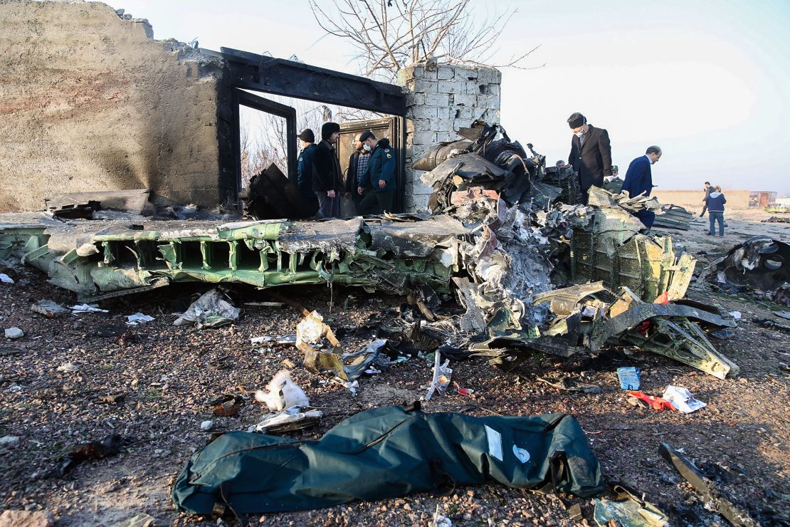 People stand near the wreckage after a Ukrainian plane carrying 176 passengers crashed near Imam Khomeini airport.