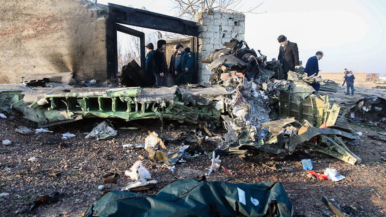 People stand near the wreckage after a Ukrainian plane carrying 176 passengers crashed near Imam Khomeini airport.
