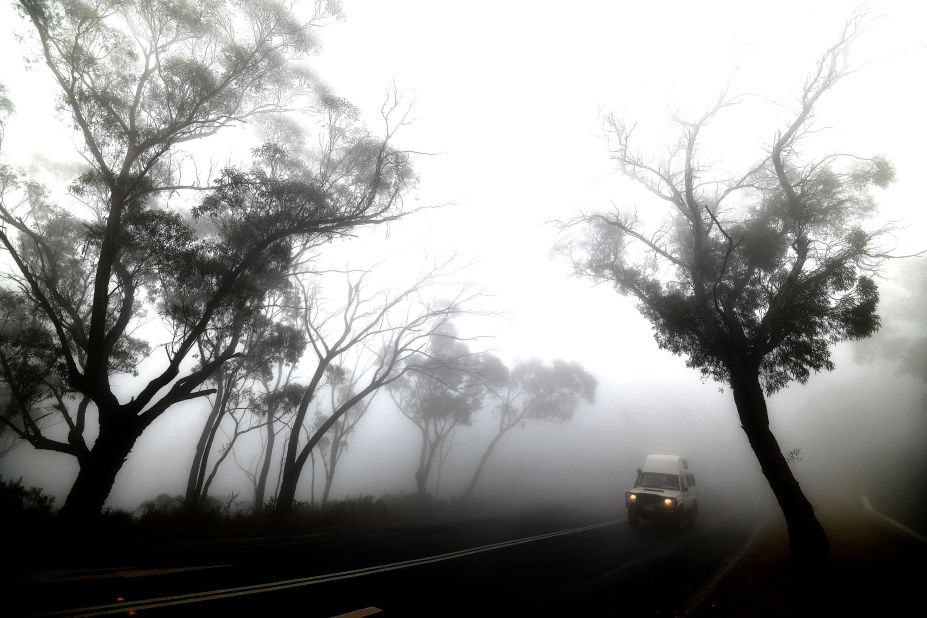 A vehicle makes its way through thick fog mixed with bushfire smoke in the Ruined Castle area of the Blue Mountains on January 11.