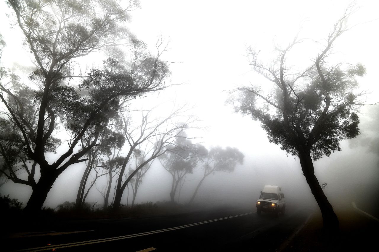 A vehicle makes its way through thick fog mixed with bushfire smoke in the Ruined Castle area of the Blue Mountains on January 11.