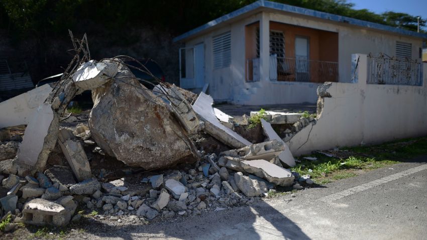 A big rock sits amid the rubble of the low wall it destroyed when it rolled down from a nearby cliff during a magnitude 5.9 earthquake in Guanica, Puerto Rico, Saturday, Jan. 11, 2020. The morning quake caused further damage along the island's southern coast, where previous recent quakes have toppled homes and schools. (AP Photo/Carlos Giusti)