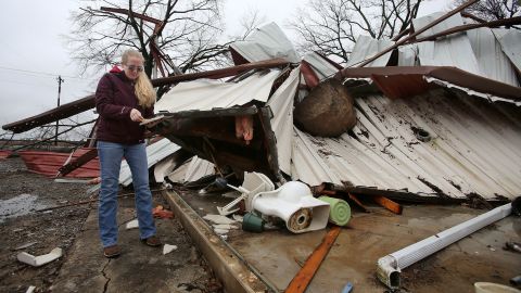 Scarlett Faulk examines her brother's Bible after recovering it from a destroyed home in Lonoke County, Arkansas.