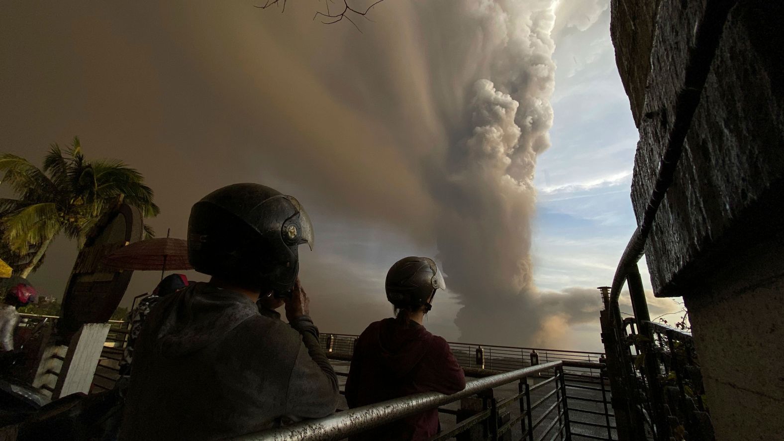 People in Tagaytay watch plumes of smoke and ash rise from the volcano on January 12.