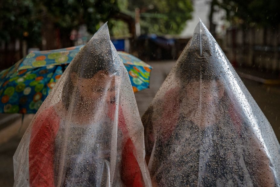 Talisay residents use plastic bags to shield themselves from ash mixed with rainwater.